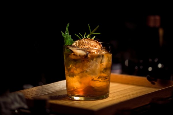How can a bar create a signature cocktail that enhances its brand identity?